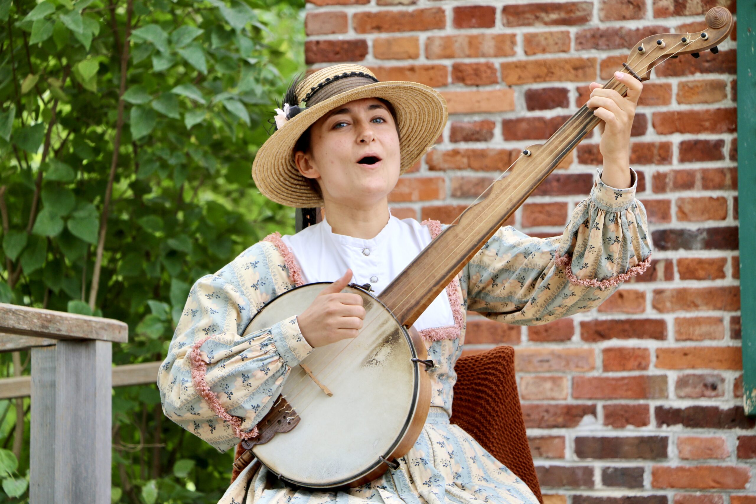 Female domestic interpreter playing the banjo.